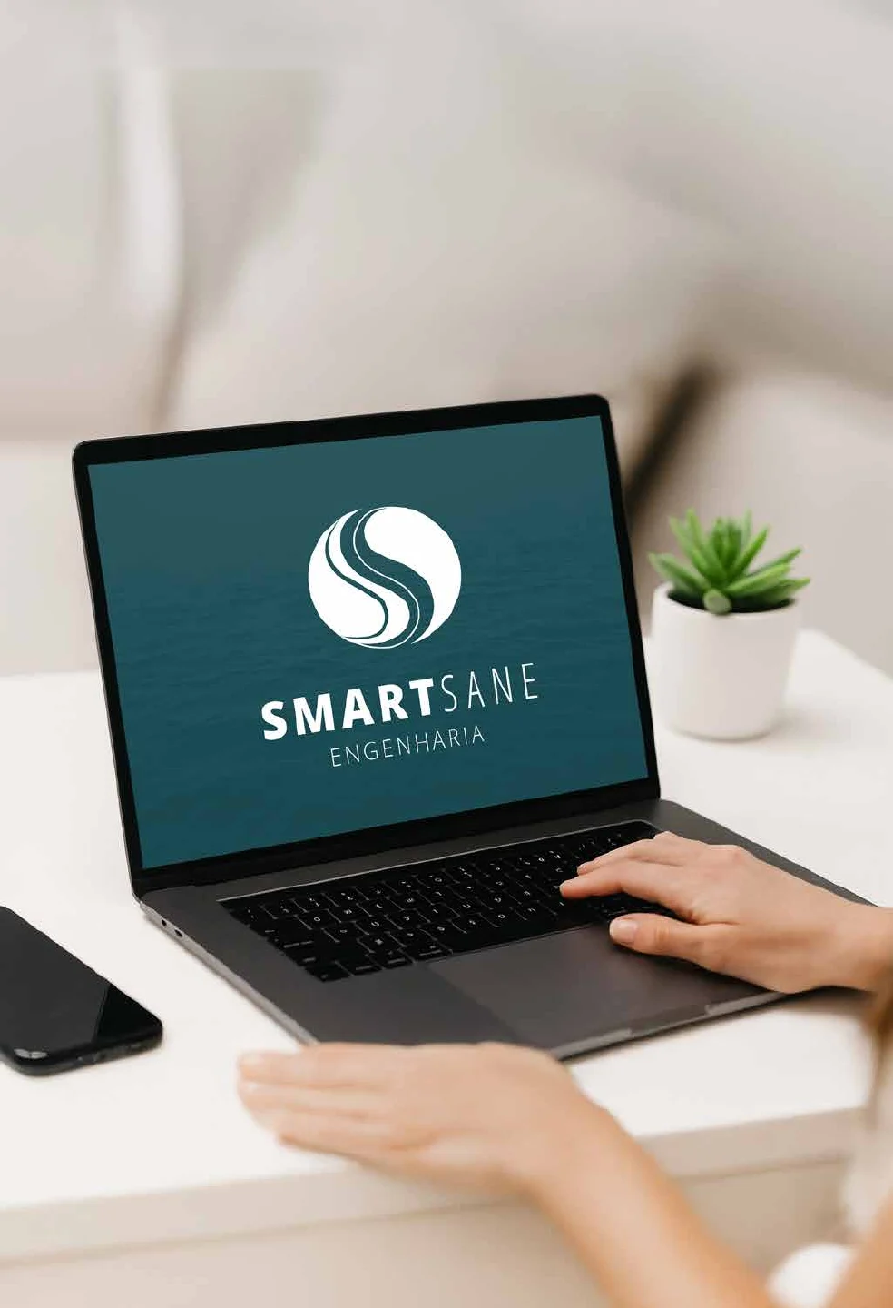 Notebook sobre uma mesa clara exibindo a tela de abertura com o logotipo SmartSane