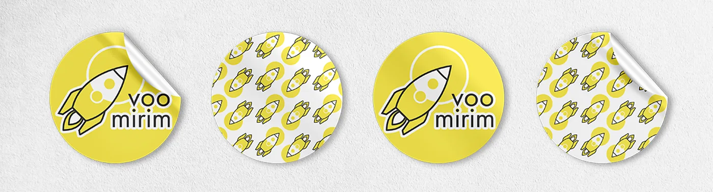 Quatro adesivos redondos: dois com o logotipo Voo Mirim sobre amarelo e dois com o padrão de foguetes