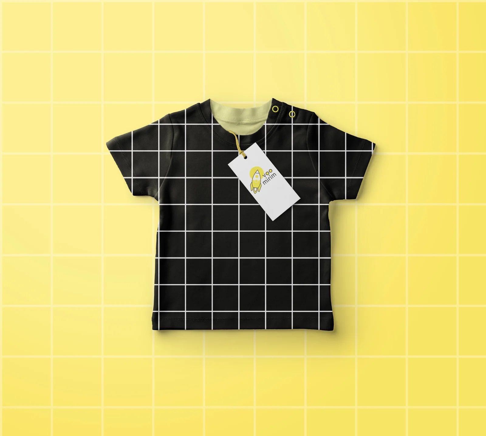 Camiseta infantil preta com quadriculado branco e tag Voo Mirim, sobre fundo amarelo