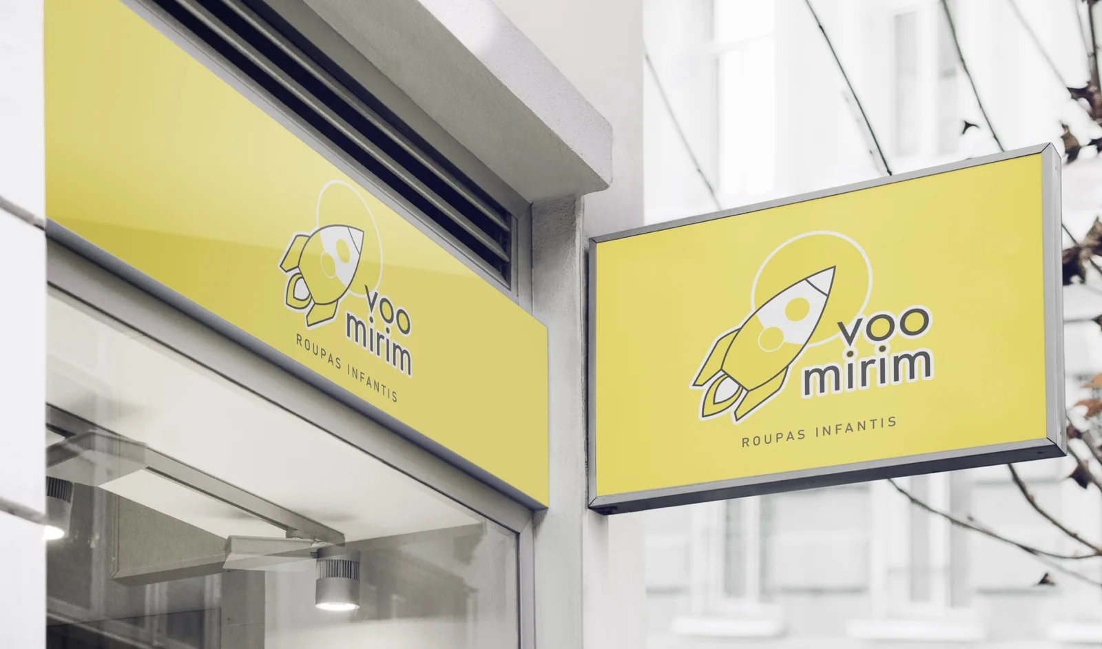 Fachada de loja e placa suspensa amarelas com a marca Voo Mirim, roupas infantis, e um foguete de traço fino