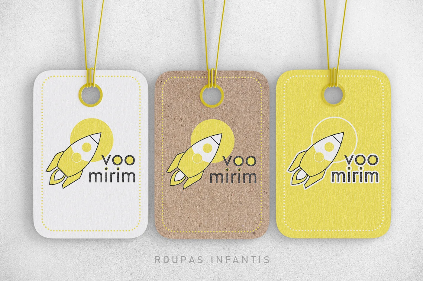 Três etiquetas Voo Mirim, em papel branco, kraft e amarelo, com o logotipo e a frase Roupas infantis